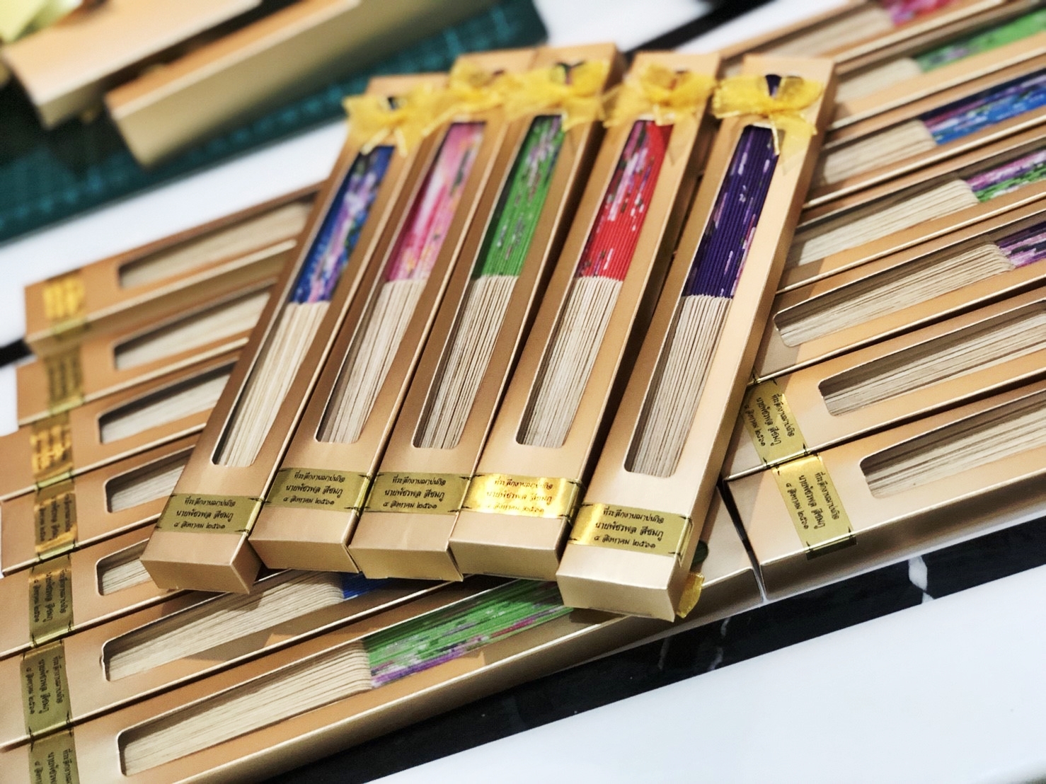 ของชำร่วยงานศพ พัดไม้ผ้าสวย ในกล่องทอง