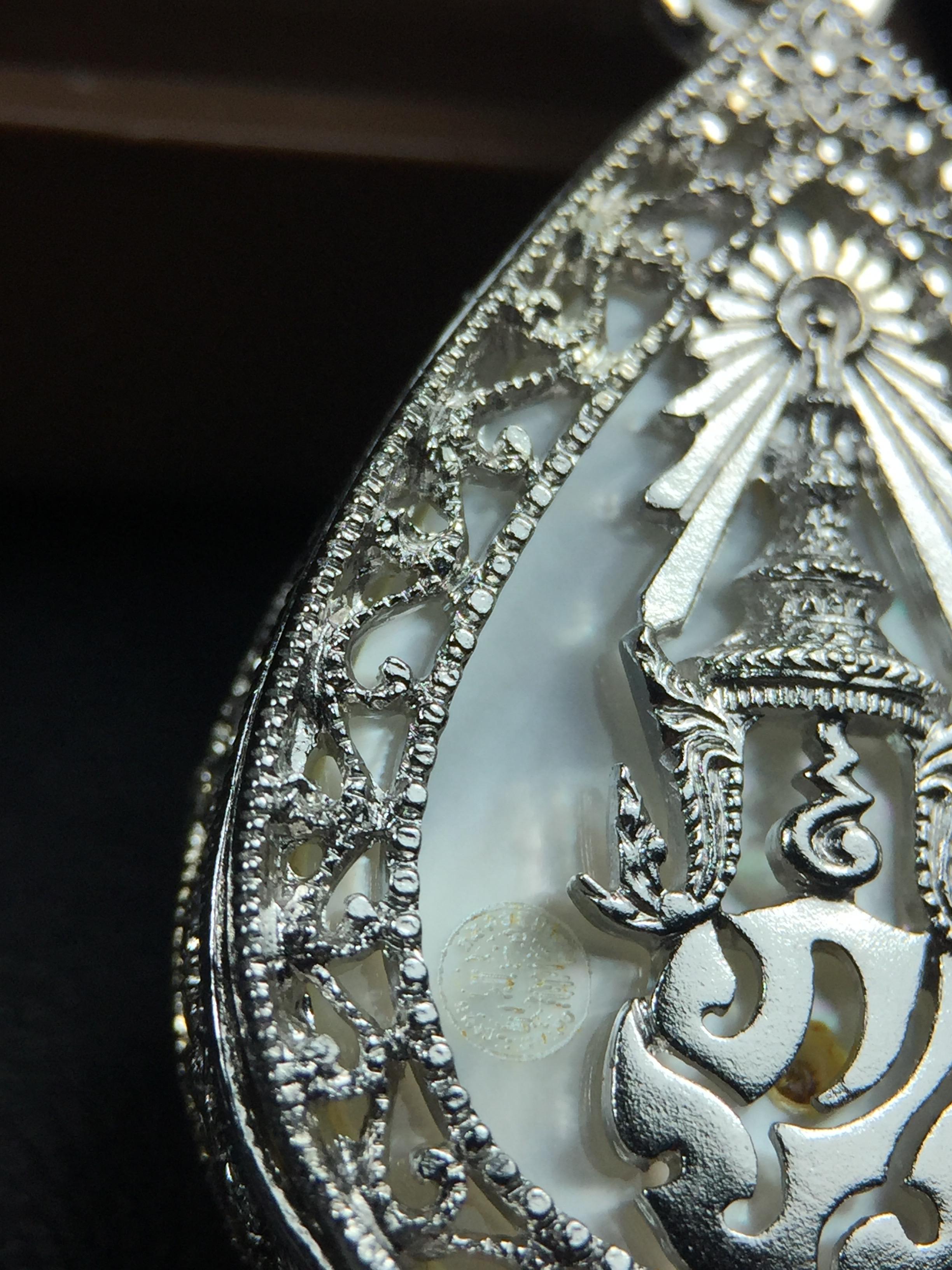 พระพุทธชินราช ภปร. โครงการ "เพราะแผ่นดินนี้ คือ แผ่นดินเกิด" ปี2548(รุ่นแรก) เหรียญทรงหยดน้ำ ขนาด 21 x 31 มม. เนื้อเงินสามกษัตริย์ องค์พระชุบสามกษัตริย์ ล้อมด้วยกรอบเงินชุบทองคำขาวสลักเสลาเป็นลวดลายละเอียดอ่อน ส่วนพื้นองค์พระเป็นเปลือกหอยมุข