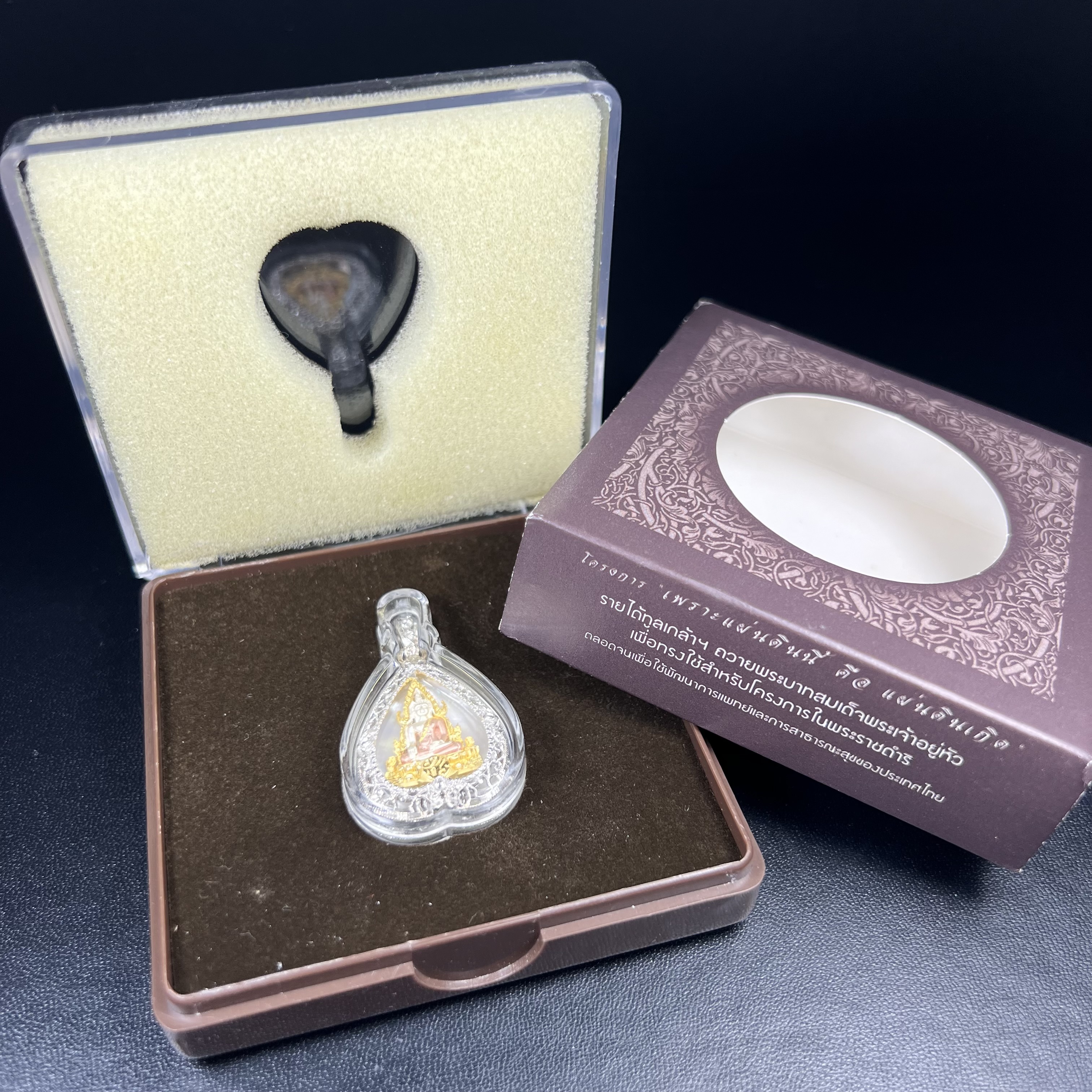 พระพุทธชินราช ภปร. โครงการ "เพราะแผ่นดินนี้ คือ แผ่นดินเกิด" ปี2548(รุ่นแรก) เหรียญทรงใบโพธิ์ ขนาด 21 x 29 มม. เนื้อเงินสามกษัตริย์ องค์พระชุบสามกษัตริย์ ล้อมด้วยกรอบเงินชุบทองคำขาวสลักเสลาเป็นลวดลายละเอียดอ่อน ส่วนพื้นองค์พระเป็นเปลือกหอยมุข