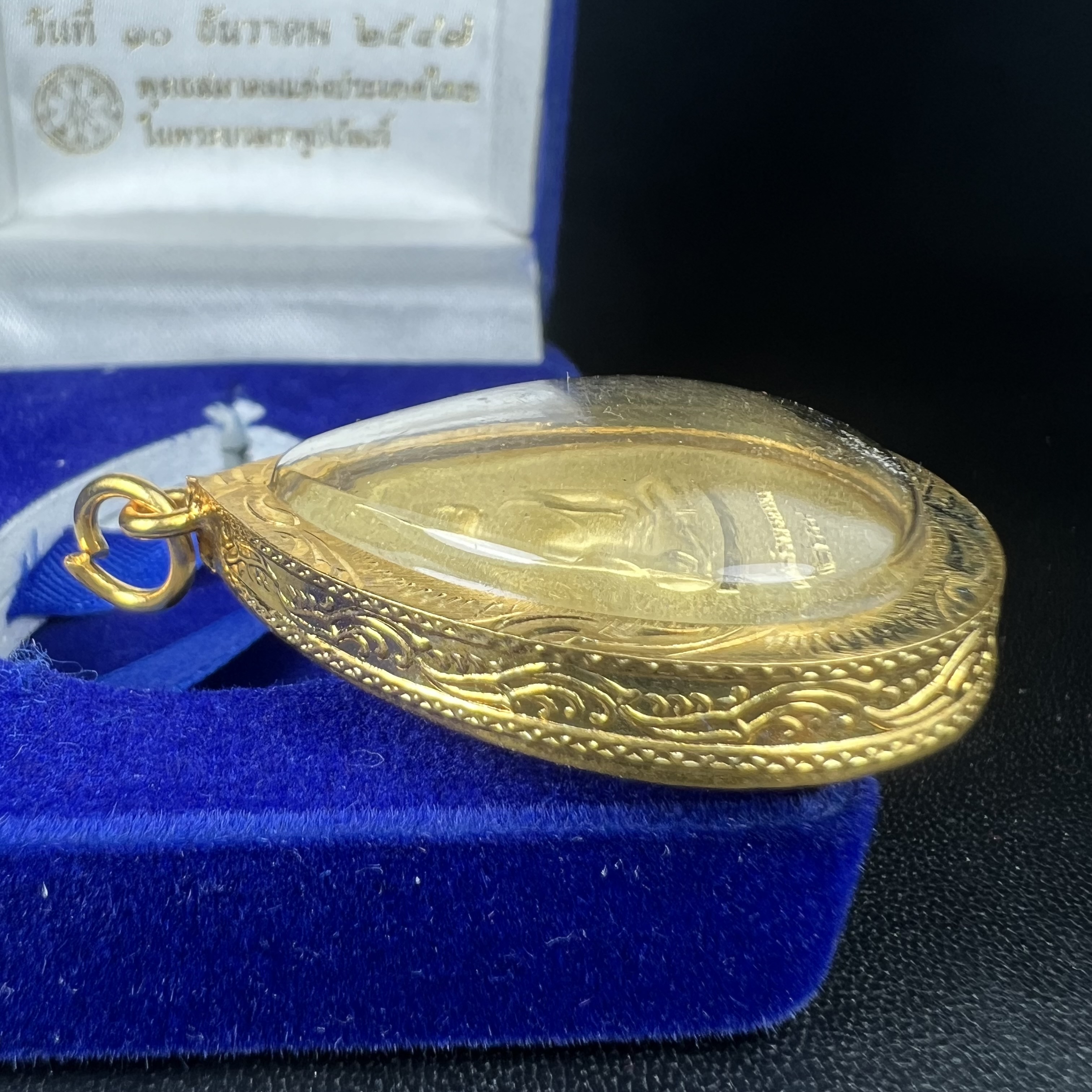 เหรียญพระพุทธสิงหธรรมมงคล ภปร. ปี 2547 ทรงหยดน้ำ ด้านหลังมี ภ.ป.ร. (ชนวนเก่า)เนื้อโลหะผสม ชุบทองพ่นทราย สูง 3.3ซม.พิธีใหญ่ มวลสารดี ปลุกเสกวัดพระแก้ว(งานเลี่ยมกรอบเดิมจากผู้จัดสร้างห่อหุ้มด้วยทองนพเกล้า)