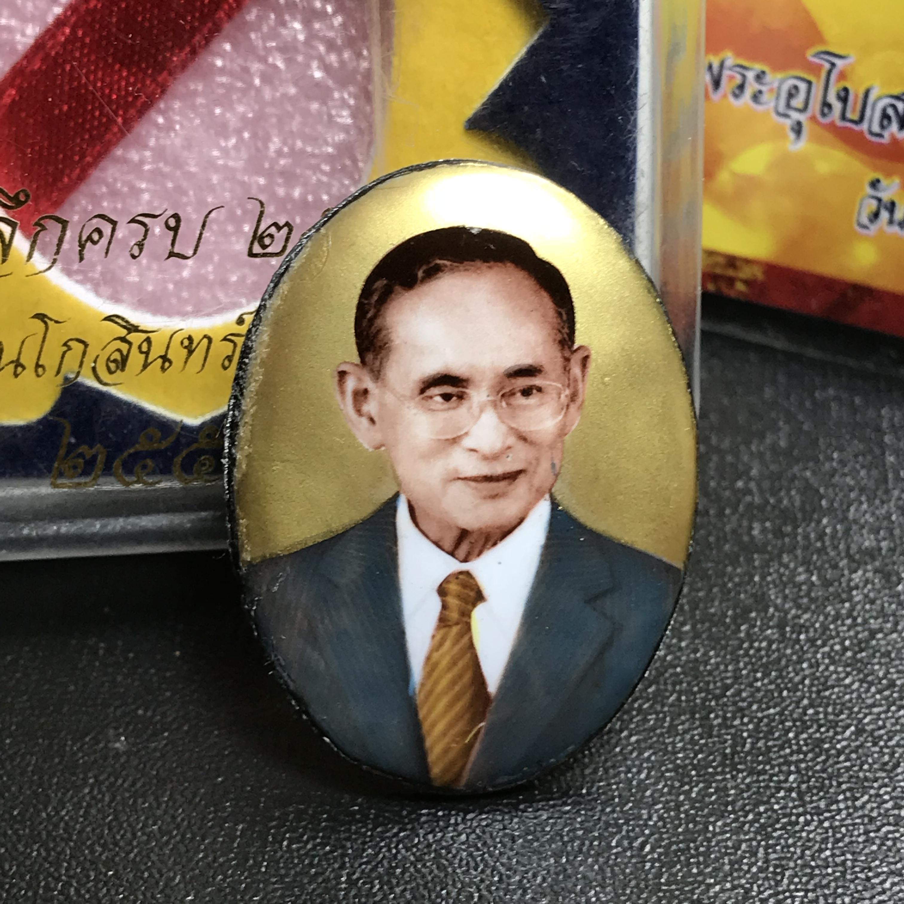 ล็อกเกตในหลวงรัชกาลที่9 ที่ระลึกครบ 25 ปี มูลนิธิศรีรัตนโกสินทร์ วัดสุทธาราม พ.ศ. 2550 พิมพ์ทรงวงรีรูปไข่ใหญ่ ฉากสีทอง หลังปิดแผ่นโลหะสีขาว(สแตนเลส)ฝังพระยอดธง(นิยม)