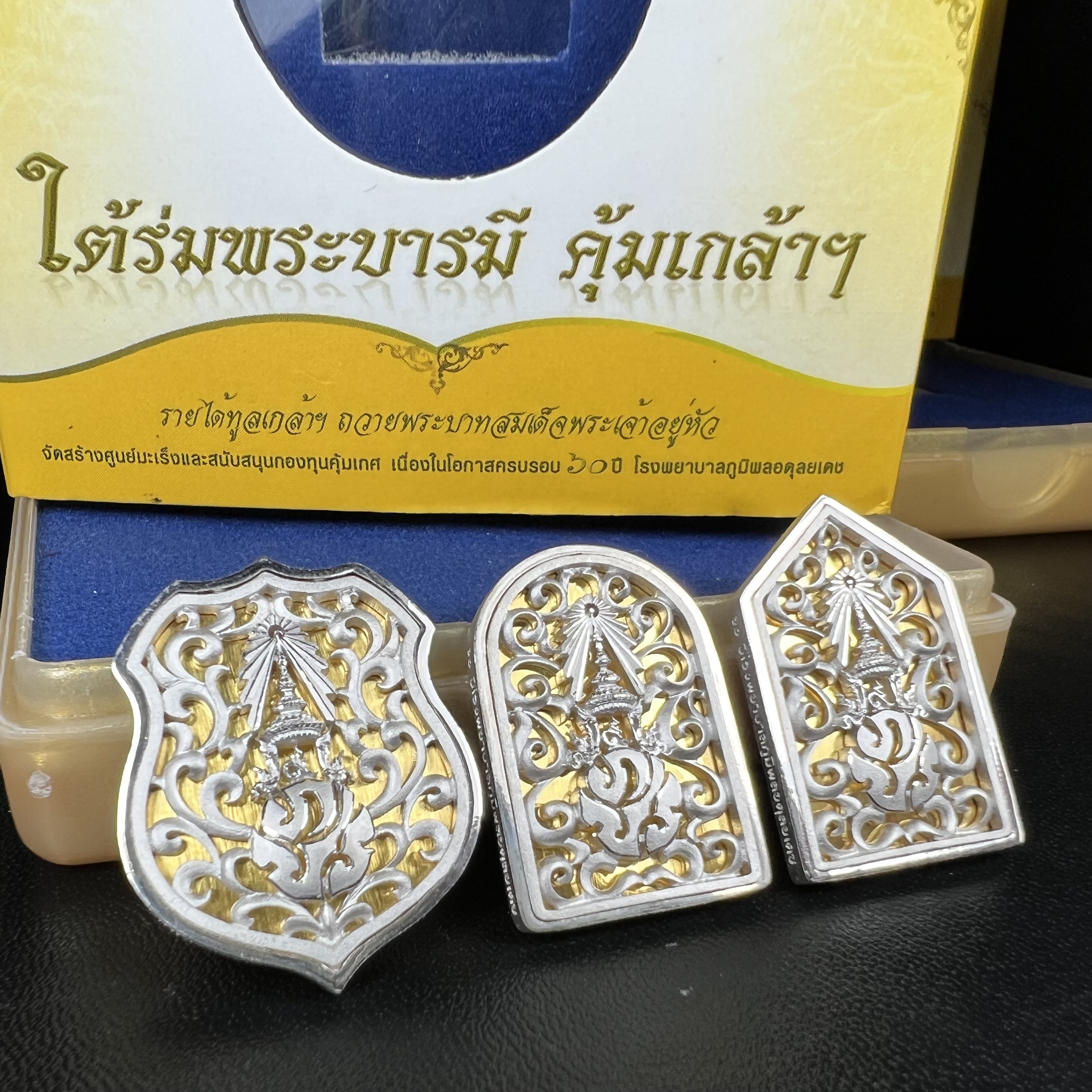 พระพุทธรูปคุ้มเกล้าฯ ภปร.(ใต้ร่มพระบารมี คุ้มเกล้า) 60ปี รพ.ภูมิพลฯ พ.ศ.2552 เหรียญเนื้อเงิน ชุบทองคำขาว(พิมพ์ รูปอาร์ม+รูปใบมะขาม+รูปห้าเหลี่ยม)(1ชุด 3 พิมพ์ ครบทุกแบบที่จัดสร้าง)1 ใน 5000 เหรียญ ครบชุดหายาก