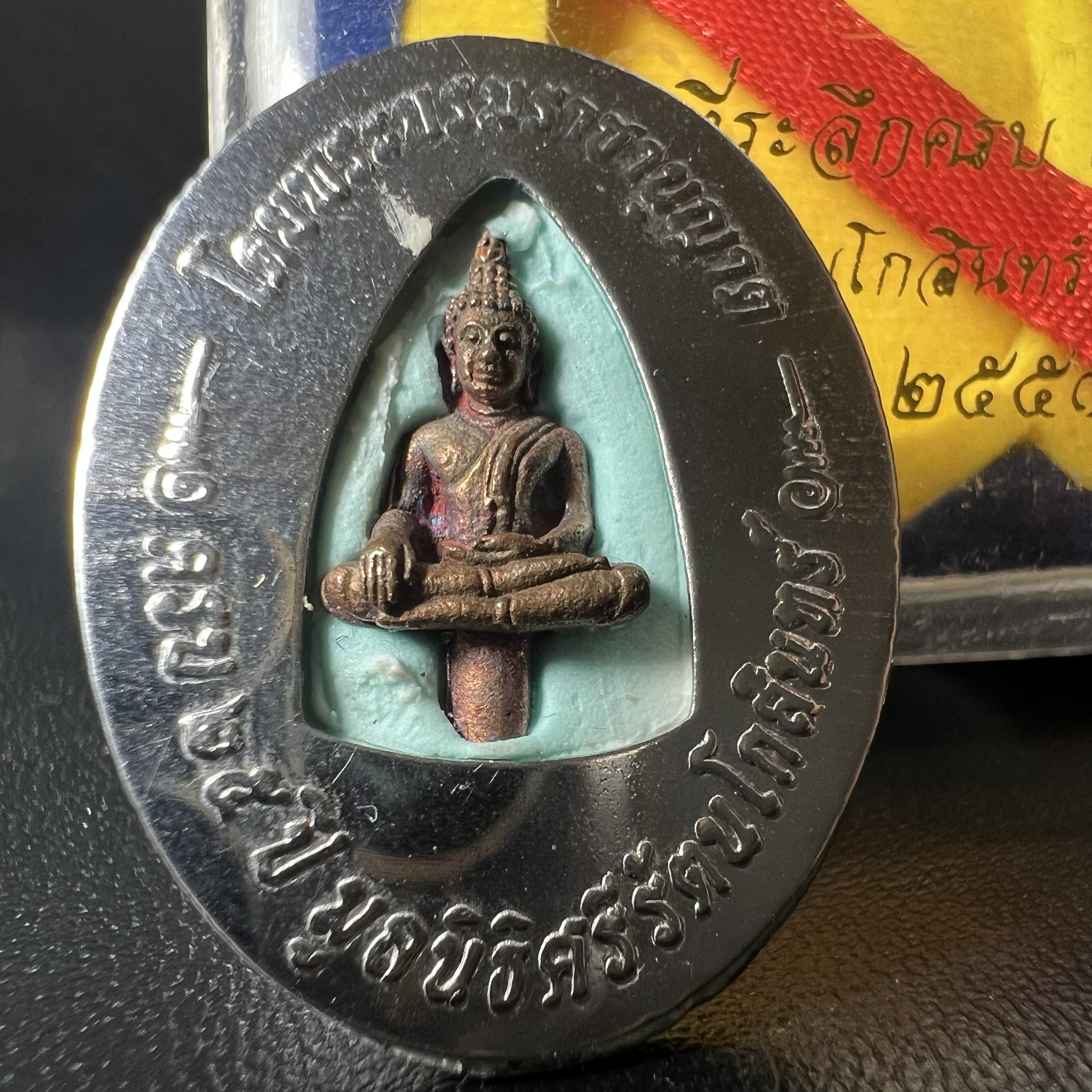 ล็อกเกตในหลวงรัชกาลที่9 ที่ระลึกครบ 25 ปี มูลนิธิศรีรัตนโกสินทร์ วัดสุทธาราม พ.ศ. 2550 พิมพ์ทรงวงรีรูปไข่เล็กฉากสีทอง หลังปิดแผ่นโลหะสีขาว(สแตนเลส)ฝังพระยอดธง(นิยม)