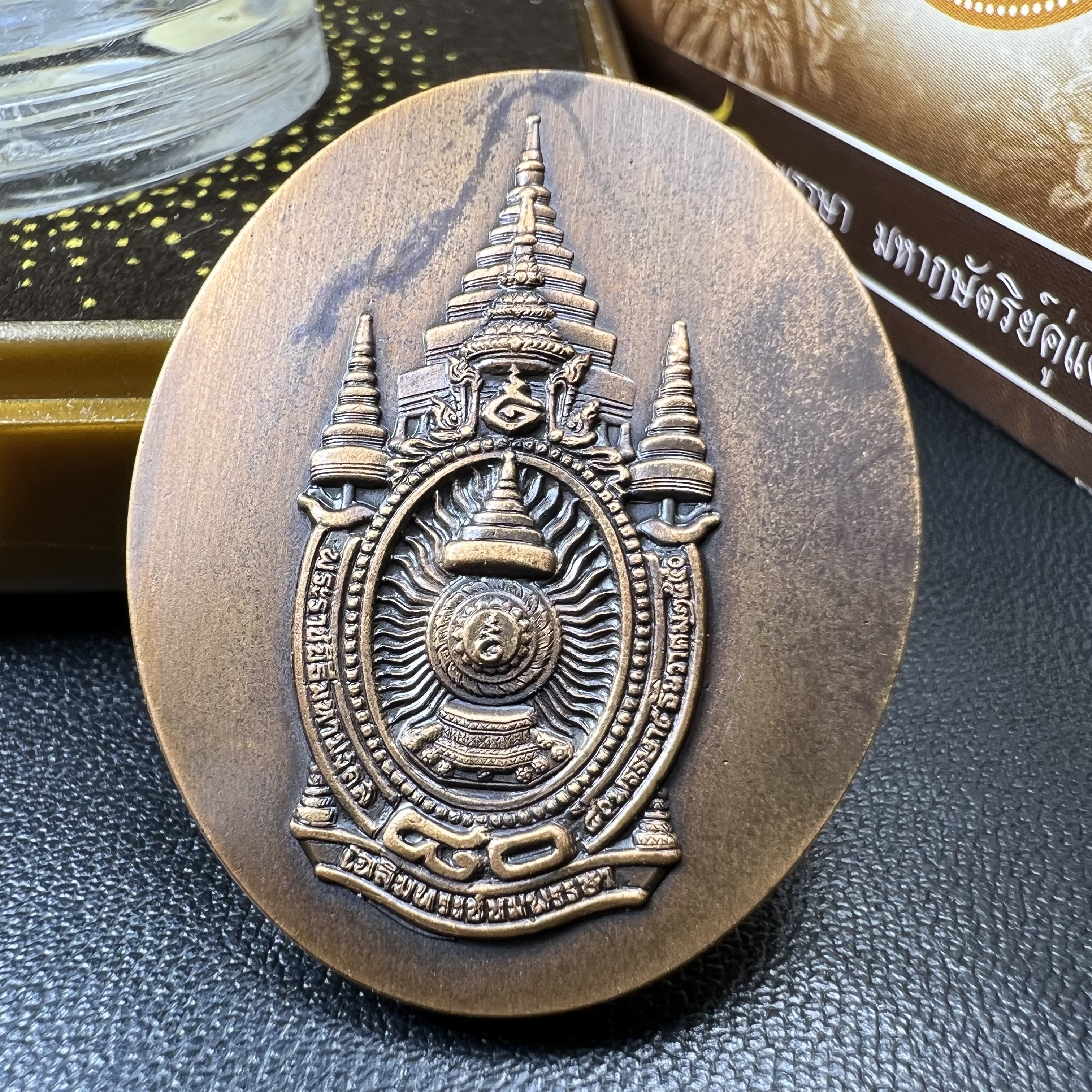 เหรียญรูปหล่อพระบาทสมเด็จพระเจ้าอยู่หัว ในหลวงทรงงาน “รุ่นเย็นศิระเพราะพระบริบาล 80พรรษา มหากษัตริย์คู่แผ่นดินสยาม” พ.ศ.2550 เนื้อทองแดงรมดำ(ขนาด 27*35 มม.)พร้อมกล่องบรรจุเดิมครบ