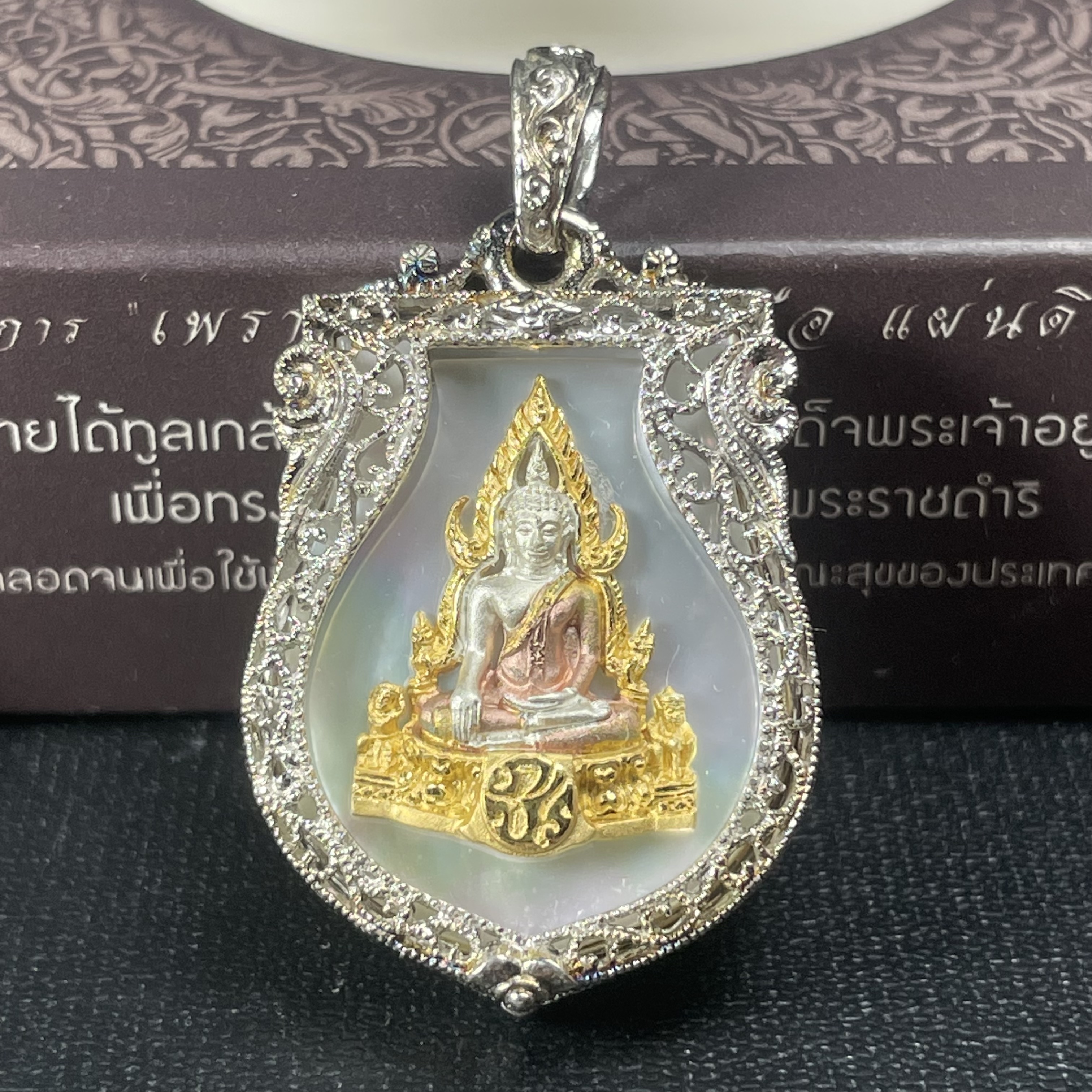 พระพุทธชินราช ภปร. โครงการ "เพราะแผ่นดินนี้ คือ แผ่นดินเกิด" ปี2548(รุ่นแรก) เหรียญทรงเสมา ขนาด 21 x 29 มม.เนื้อเงินสามกษัตริย์ องค์พระชุบสามกษัตริย์ ล้อมด้วยกรอบเงินชุบทองคำขาวสลักเสลาเป็นลวดลายละเอียดอ่อน ส่วนพื้นองค์พระเป็นเปลือกหอยมุขงดงาม