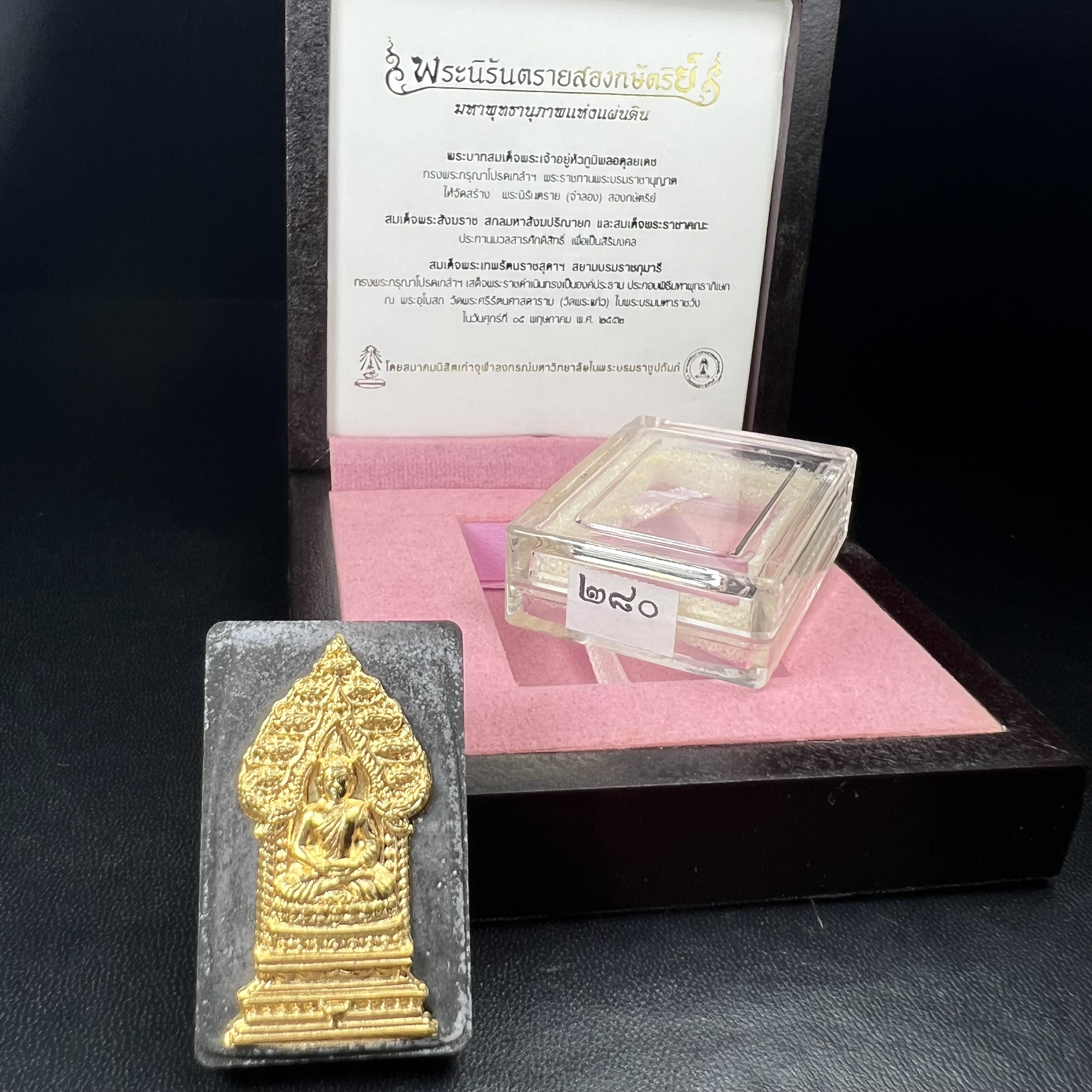 พระนิรันตรายสองกษัตริย์ มหาพุทธานุภาพแห่งแผ่นดิน ปี 2552 "พระผู้ปกป้องคุ้มครองจากภัยอันตรายทั้งปวง" พระผงพิมพ์สมเด็จหน้าปัดทอง สีดำด้านหลังฝังโลหะเงินชุบทอง เชิญอักษรพระปรมาภิไธยสองกษัตริย์(จปร.และ วปร.) พร้อมกล่องบรรจุเดิม องค์หมายเลข ๒๘๐