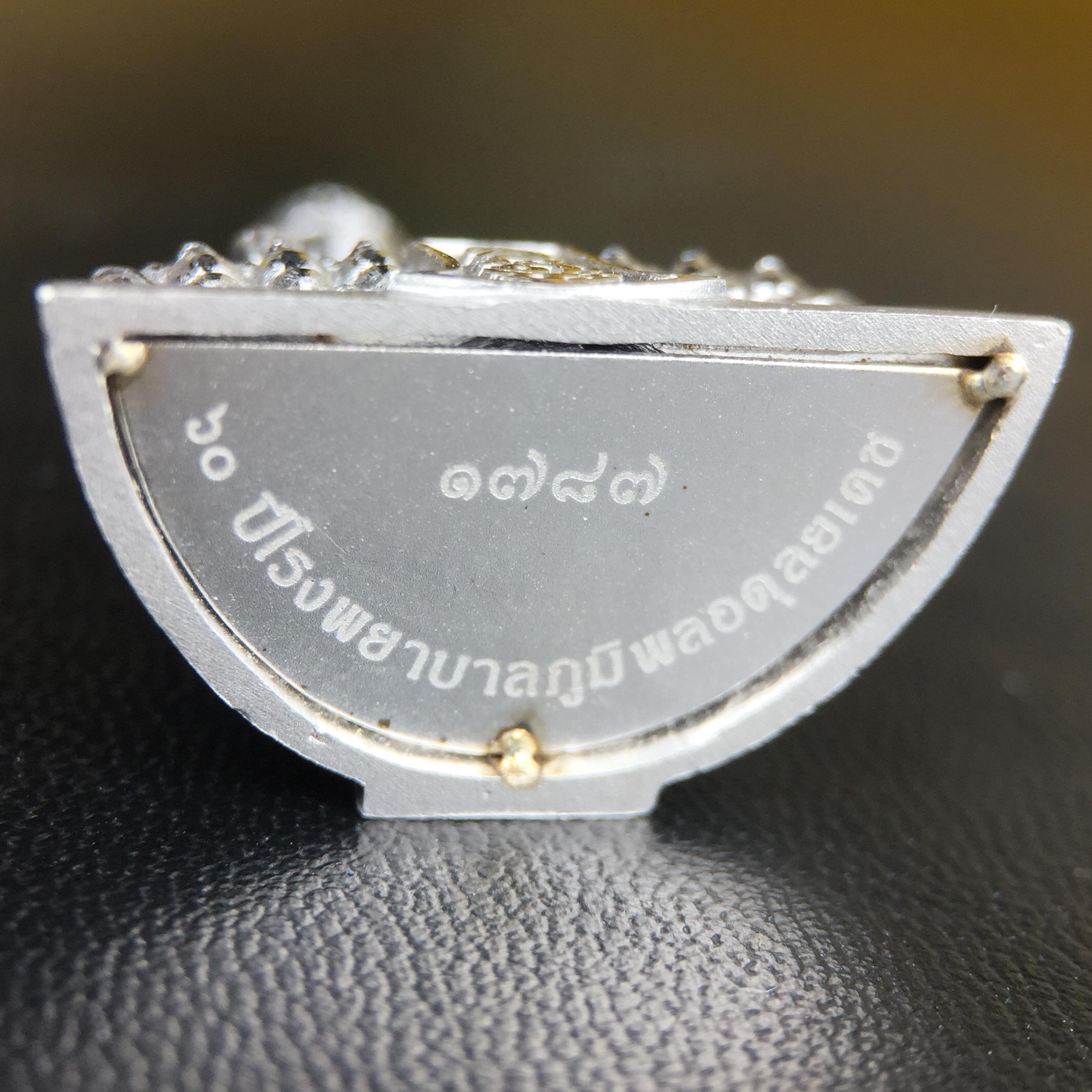 พระพุทธรูปคุ้มเกล้าฯ ภปร.(ใต้ร่มพระบารมี คุ้มเกล้า) 60ปี โรงพยาบาลภูมิพลฯ พ.ศ.2552 เนื้อเงิน ชุบทองคำขาว(พิมพ์ใหญ่ขนาด 35.5*24 มม.)สภาพสวยเดิมพร้อมกล่องบรรจุเดิม ตอกโค๊ดหมายเลขกำกับ หายาก(1ใน5000 องค์)