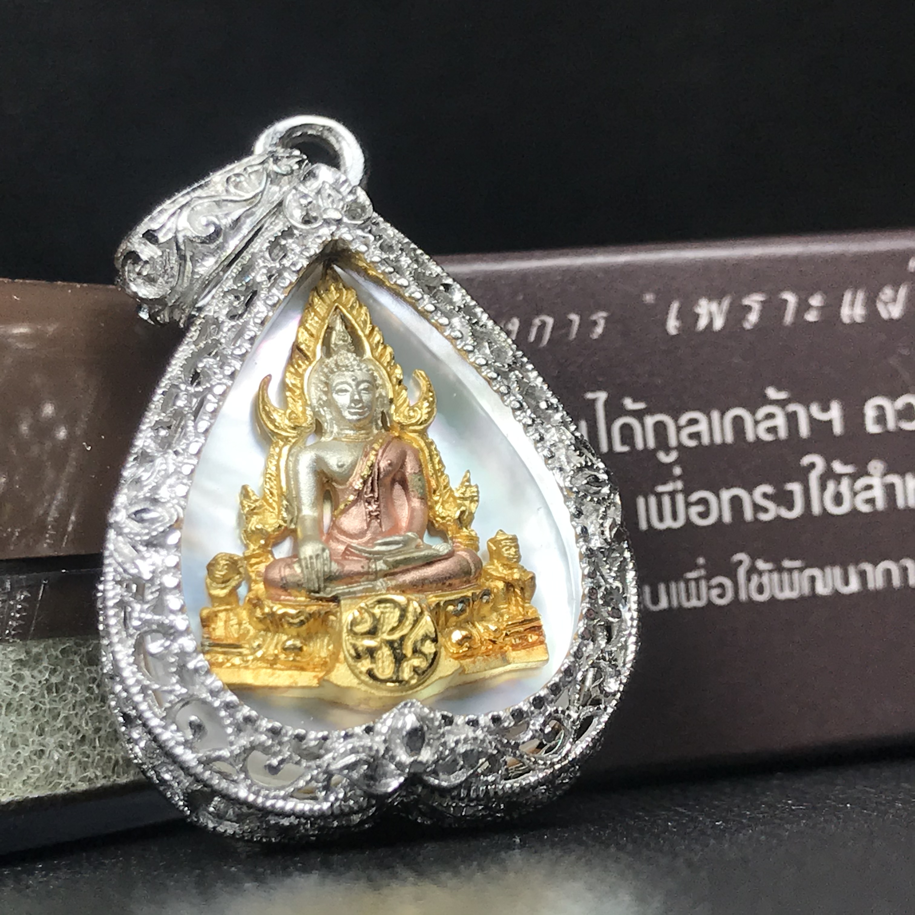 พระพุทธชินราช ภปร. โครงการ "เพราะแผ่นดินนี้ คือ แผ่นดินเกิด" ปี2548(รุ่นแรก) เหรียญทรงใบโพธิ์ ขนาด 21 x 29 มม. เนื้อเงินสามกษัตริย์ องค์พระชุบสามกษัตริย์ ล้อมด้วยกรอบเงินชุบทองคำขาวสลักเสลาเป็นลวดลายละเอียดอ่อน ส่วนพื้นองค์พระเป็นเปลือกหอยมุข