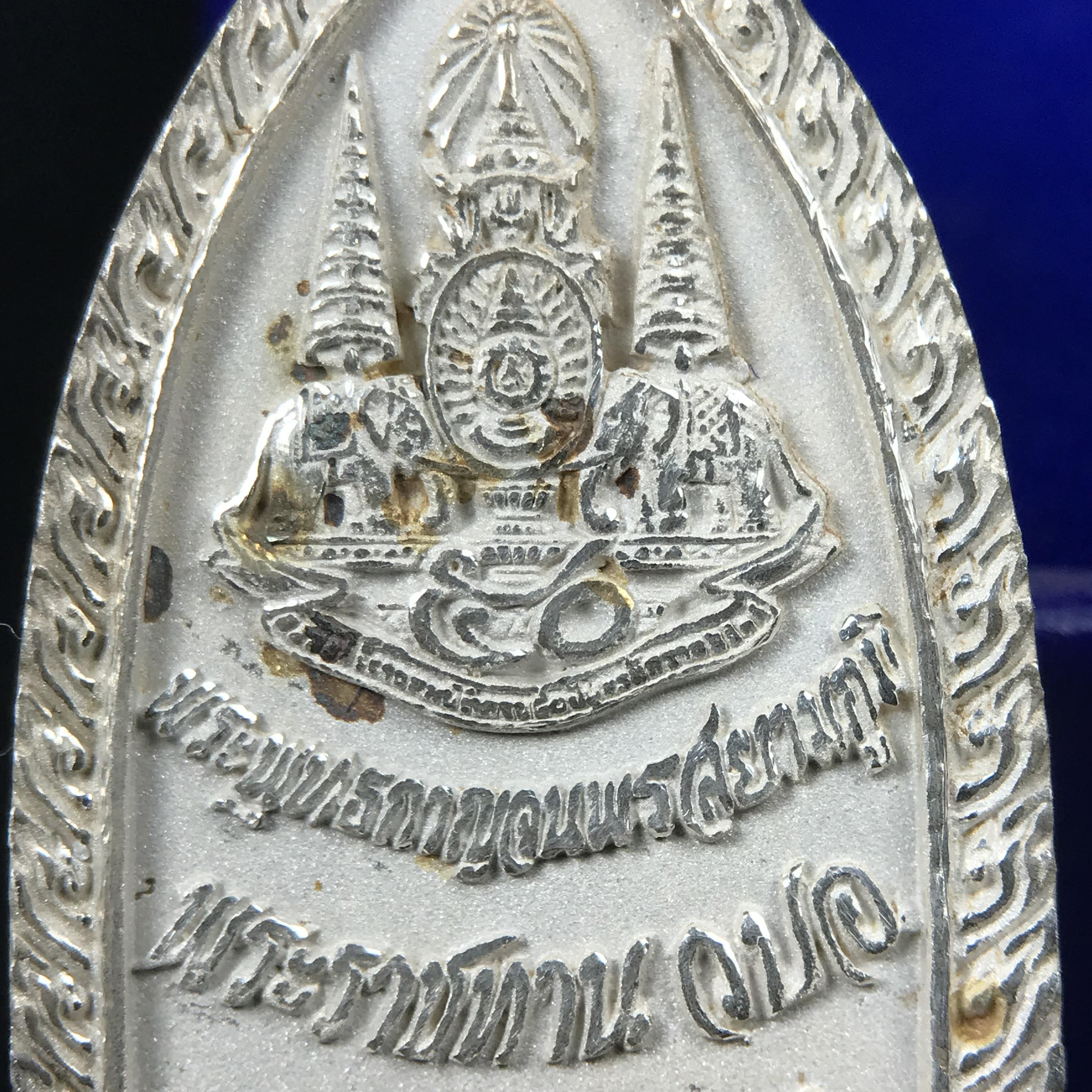 พระพุทธกาญจนพรสยามภูมิ ภปร. ปี 2539 เนื้อเงินพื้นทรายประกาย(ผิวเดิมสวย) พิมพ์ทรงใบขนุน ขนาด3.2ซม. พระพุทธรูปประจำพระชนมวาร รัชกาลที่9 ทรงโปรดเกล้าให้วิทยาลัยป้องกันราชอาณาจักร(วปอ.)สร้างในวโรกาสทรงครองสิริราชสมบัติครบ50ปี พ.ศ.2539(1ใน5000องค์)