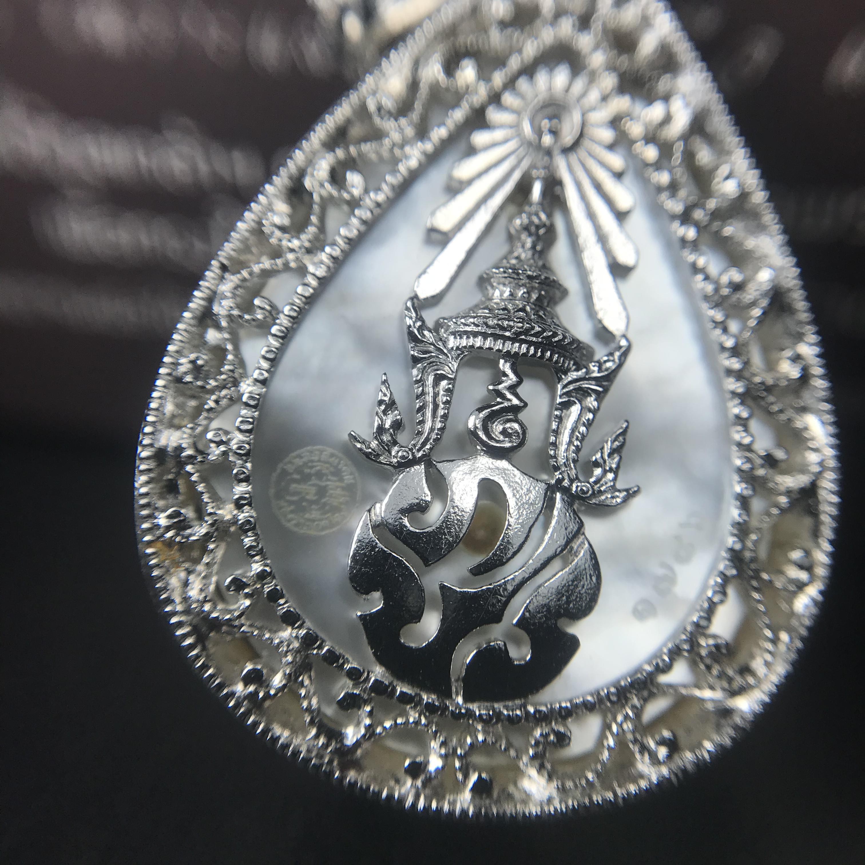 พระพุทธชินราช ภปร. โครงการ "เพราะแผ่นดินนี้ คือ แผ่นดินเกิด" ปี2548(รุ่นแรก) เหรียญทรงหยดน้ำ ขนาด 21 x 31 มม. เนื้อเงินสามกษัตริย์ องค์พระชุบสามกษัตริย์ ล้อมด้วยกรอบเงินชุบทองคำขาวสลักเสลาเป็นลวดลายละเอียดอ่อน ส่วนพื้นองค์พระเป็นเปลือกหอยมุข