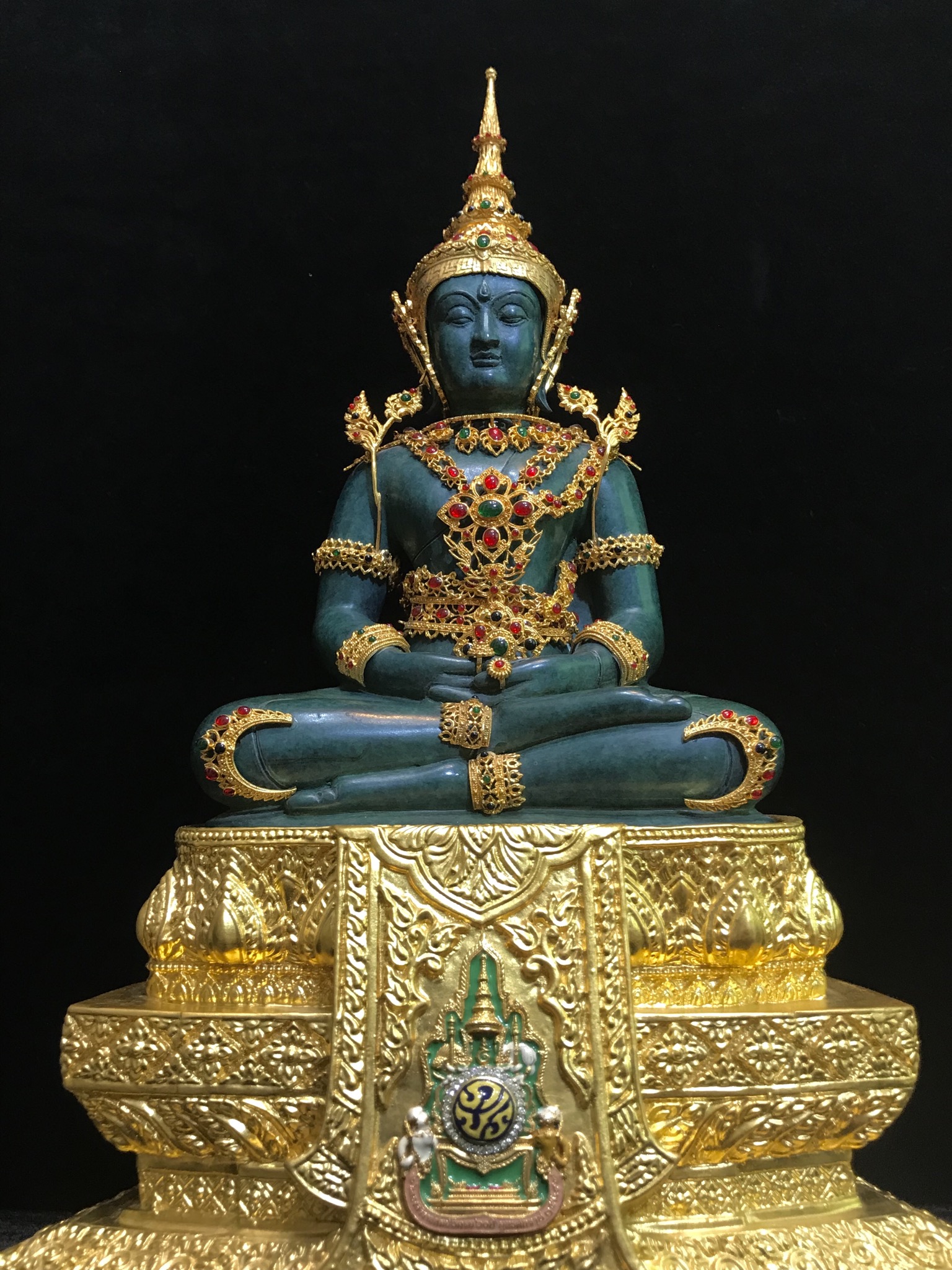 พระแก้วมรกต(จำลอง)ลอยองค์ ขนาดหน้าตัก 5 นิ้ว ทรงเครื่องฤดูร้อน เนื้อโลหะเคลือบสีเขียว เครื่องทรงชุบทองลงยาสี ฐานเนื้อโลหะ ลงรักปิดทองคำ ประดิษฐานตราสัญลักษณ์ฉลองสิริราชสมบัติ ครบ 60 ปี