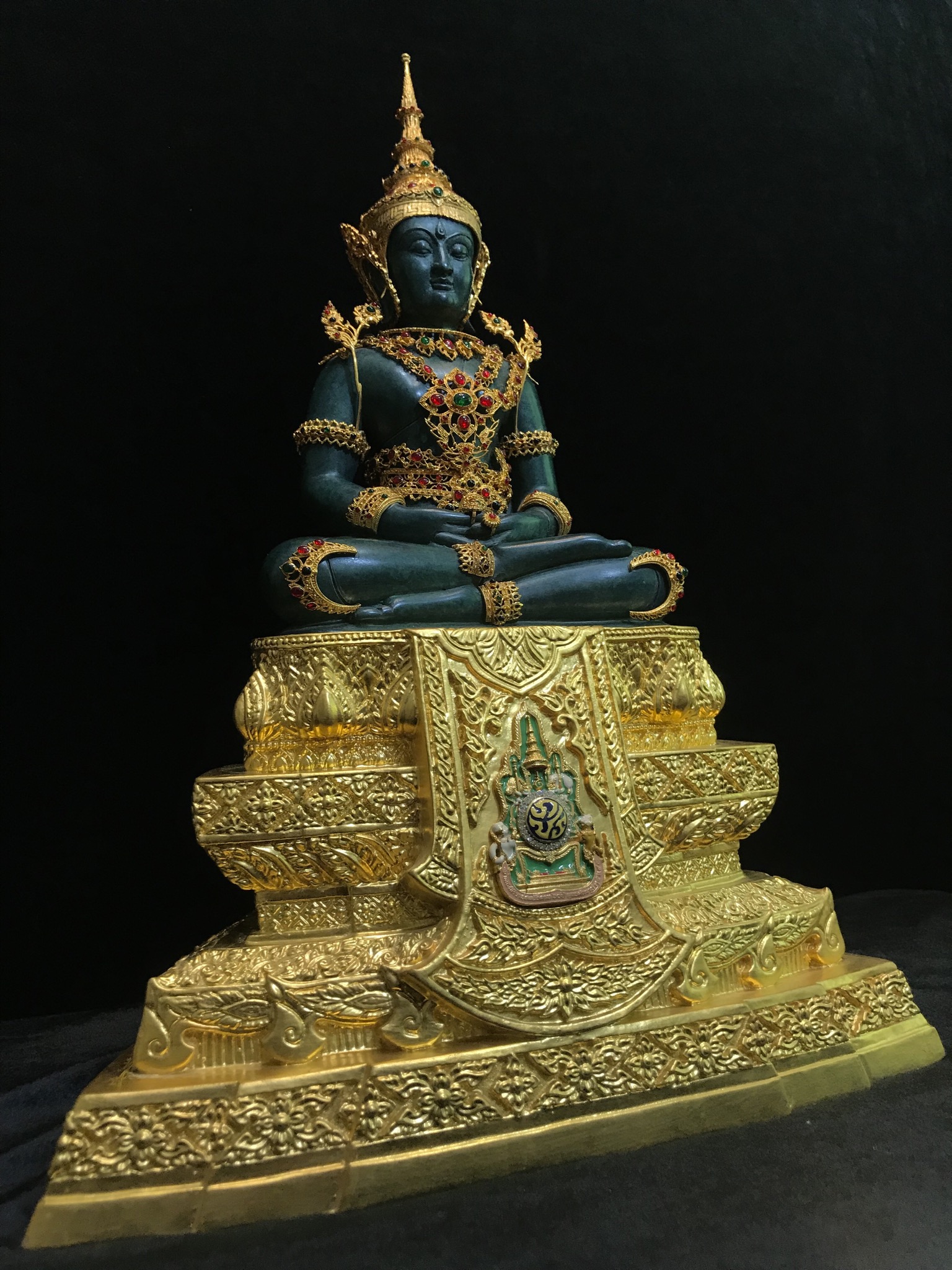 พระแก้วมรกต(จำลอง)ลอยองค์ ขนาดหน้าตัก 5 นิ้ว ทรงเครื่องฤดูร้อน เนื้อโลหะเคลือบสีเขียว เครื่องทรงชุบทองลงยาสี ฐานเนื้อโลหะ ลงรักปิดทองคำ ประดิษฐานตราสัญลักษณ์ฉลองสิริราชสมบัติ ครบ 60 ปี