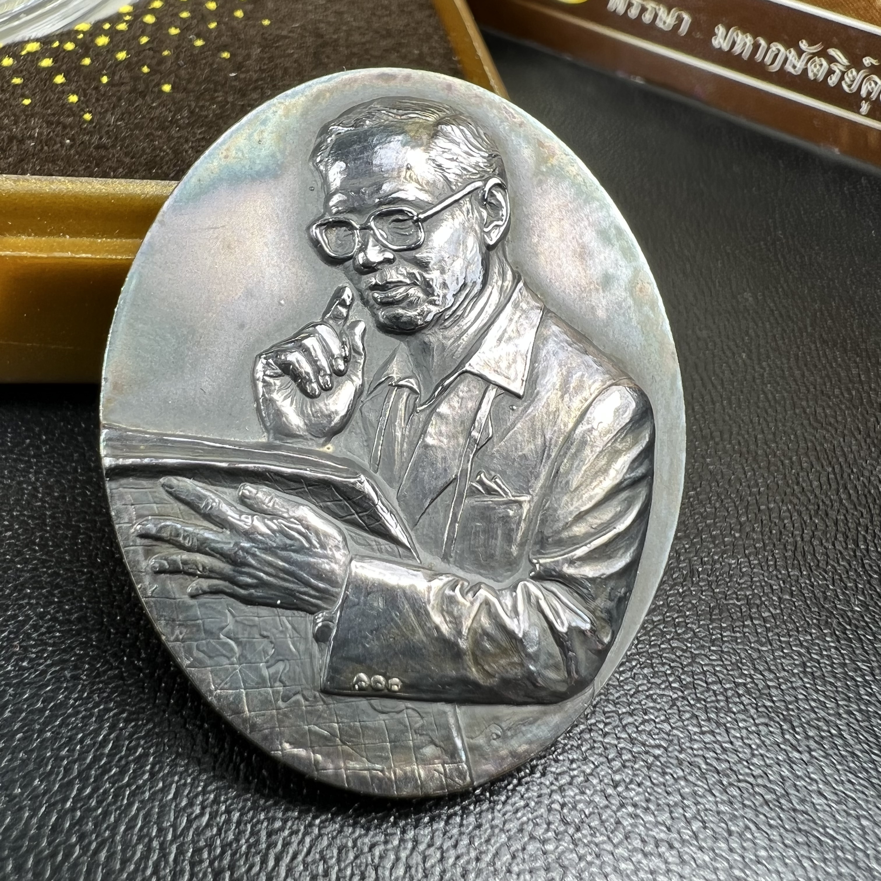 เหรียญรูปหล่อพระบาทสมเด็จพระเจ้าอยู่หัว ในหลวงทรงงาน “รุ่นเย็นศิระเพราะพระบริบาล 80พรรษา มหากษัตริย์คู่แผ่นดินสยาม” พ.ศ.2550 เนื้อเงินรมดำ(ขนาด 27*35 มม.) พร้อมกล่องบรรจุเดิมครบ