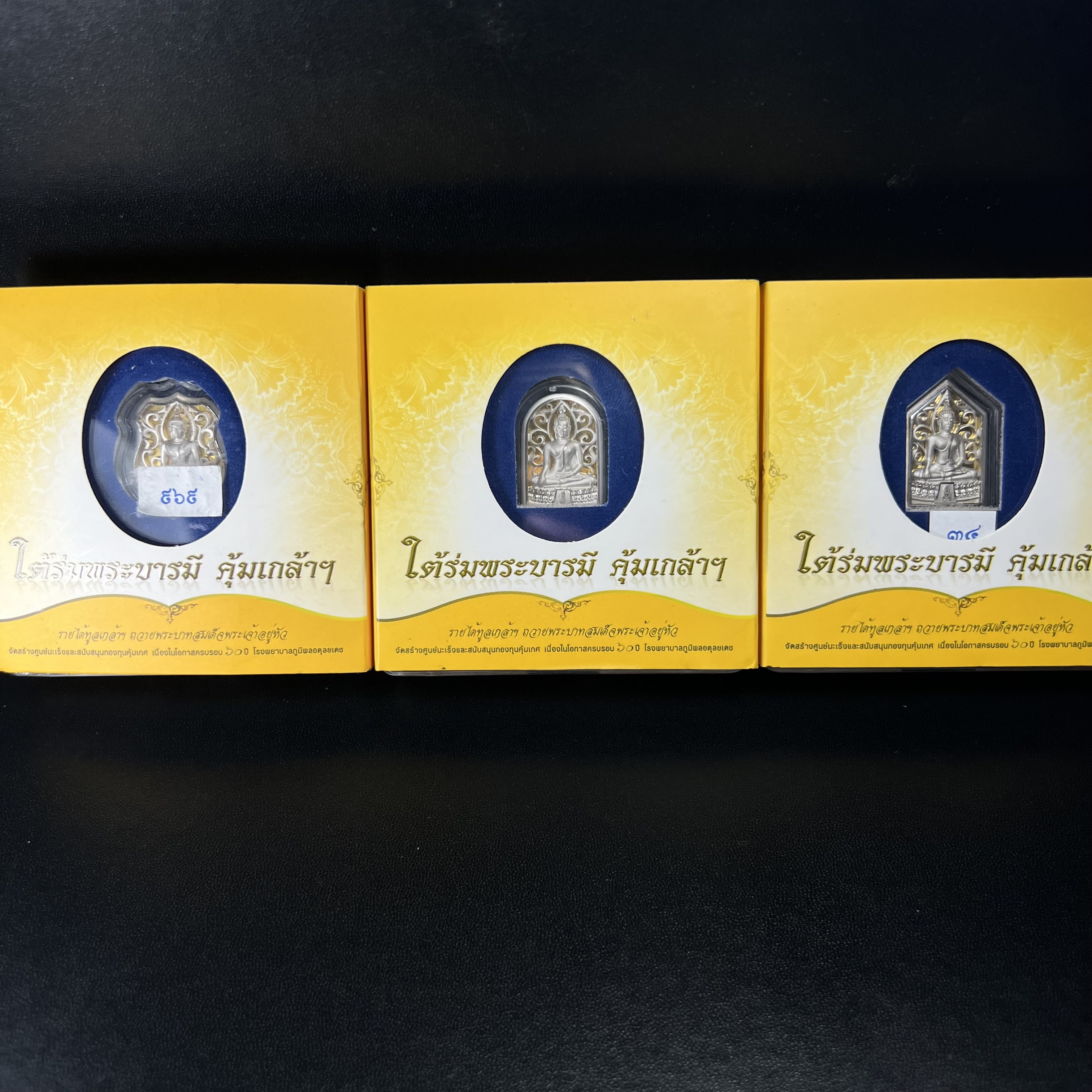 พระพุทธรูปคุ้มเกล้าฯ ภปร.(ใต้ร่มพระบารมี คุ้มเกล้า) 60ปี รพ.ภูมิพลฯ พ.ศ.2552 เหรียญเนื้อเงิน ชุบทองคำขาว(พิมพ์ รูปอาร์ม+รูปใบมะขาม+รูปห้าเหลี่ยม)(1ชุด 3 พิมพ์ ครบทุกแบบที่จัดสร้าง)1 ใน 5000 เหรียญ ครบชุดหายาก